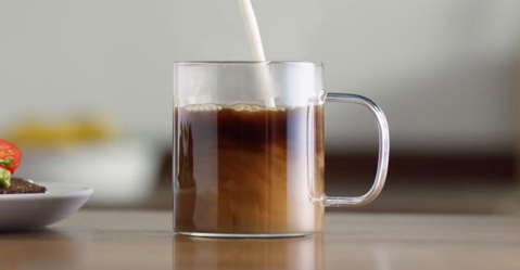 Milk being poured into a coffee mug