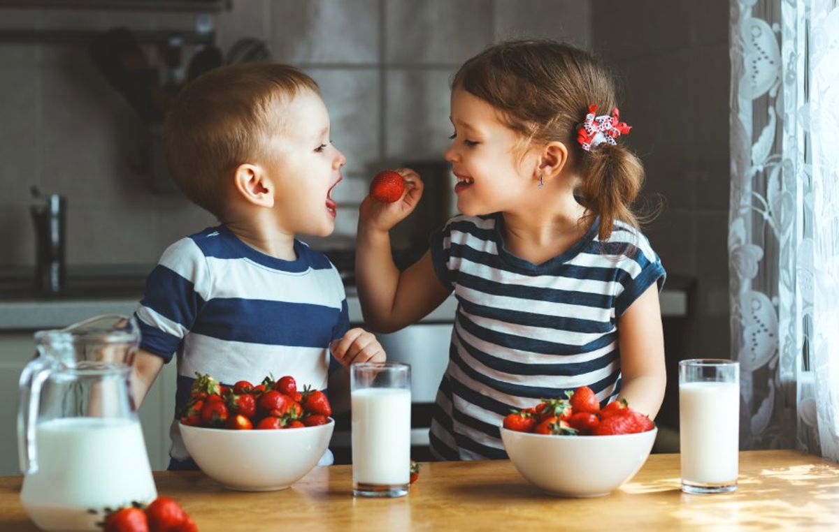Brother and sister enjoying strawberries