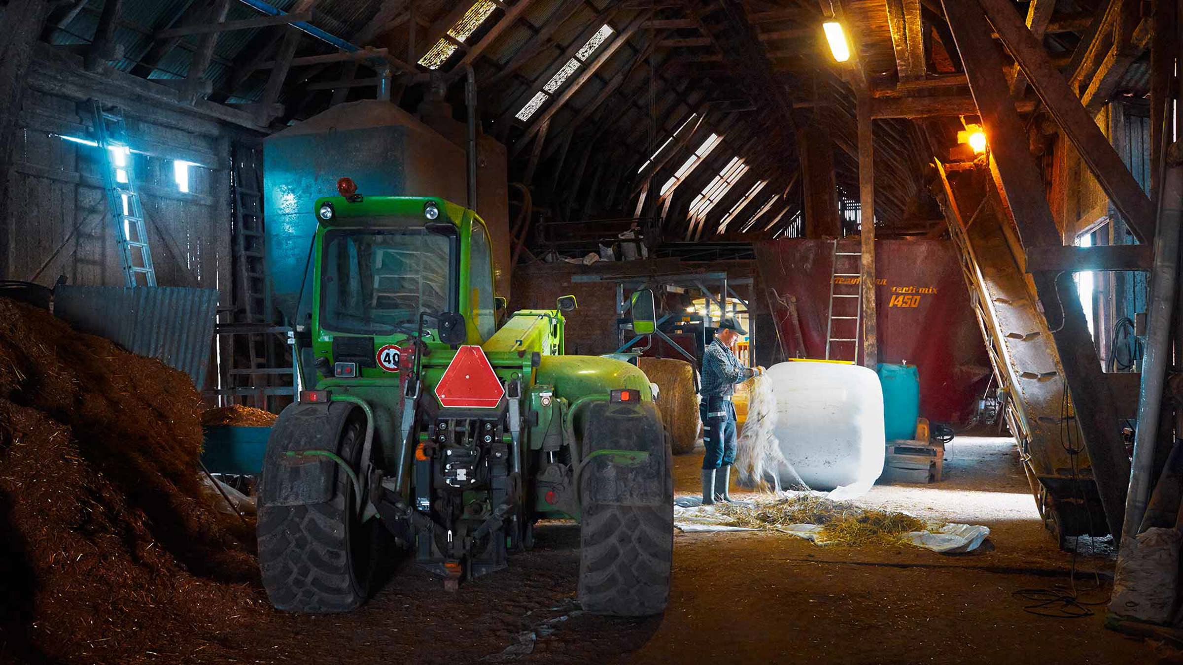 A farmer and his tractor in a barn