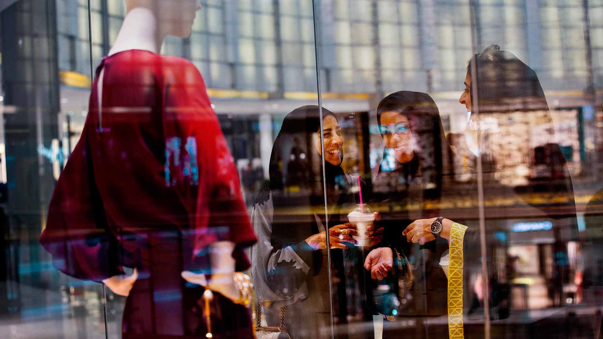 Three women laughing infront of a shop window