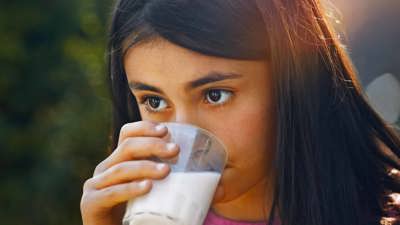 A girl drinking a glass of milk