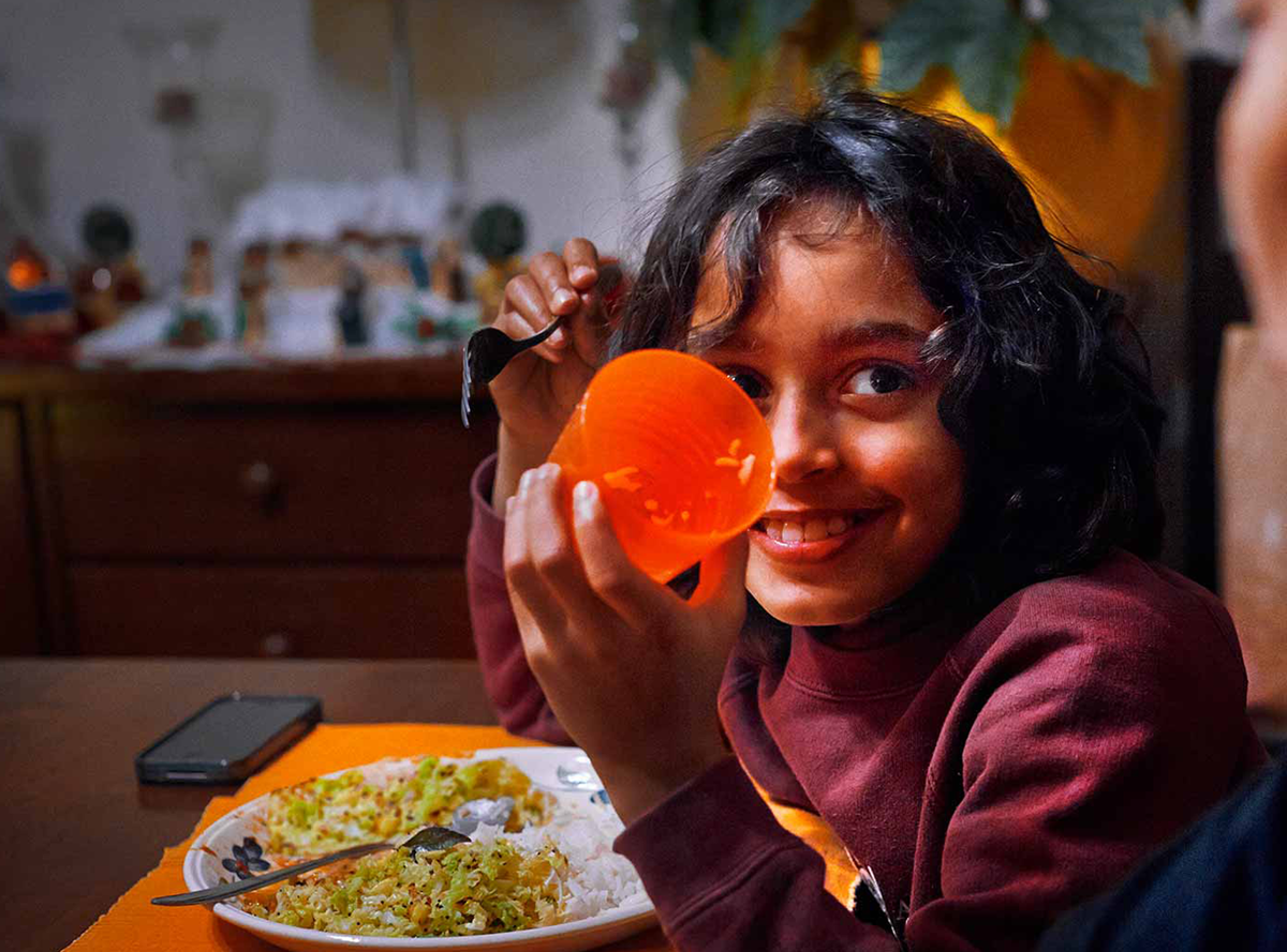 Child presenting their cup at the dinner table