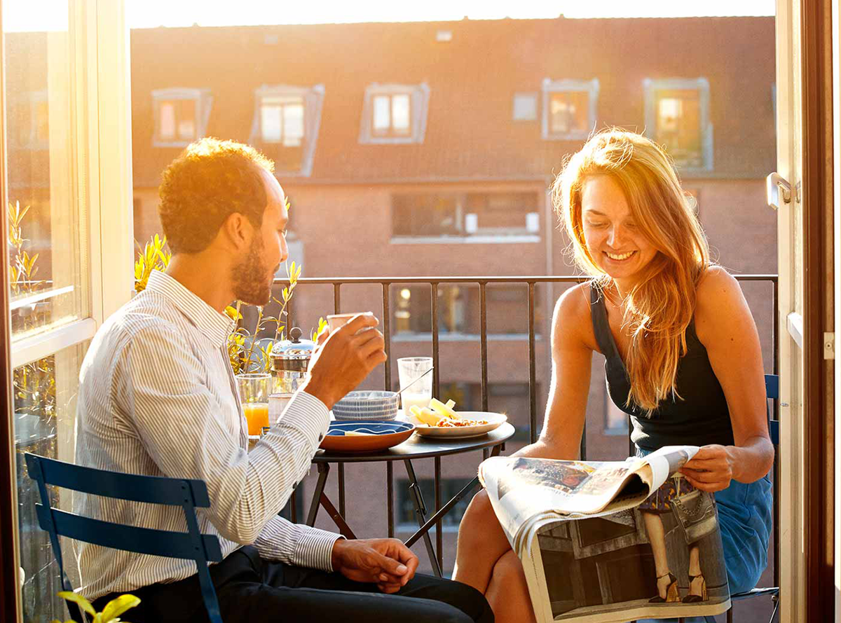 A couple eating a meal on a balcony