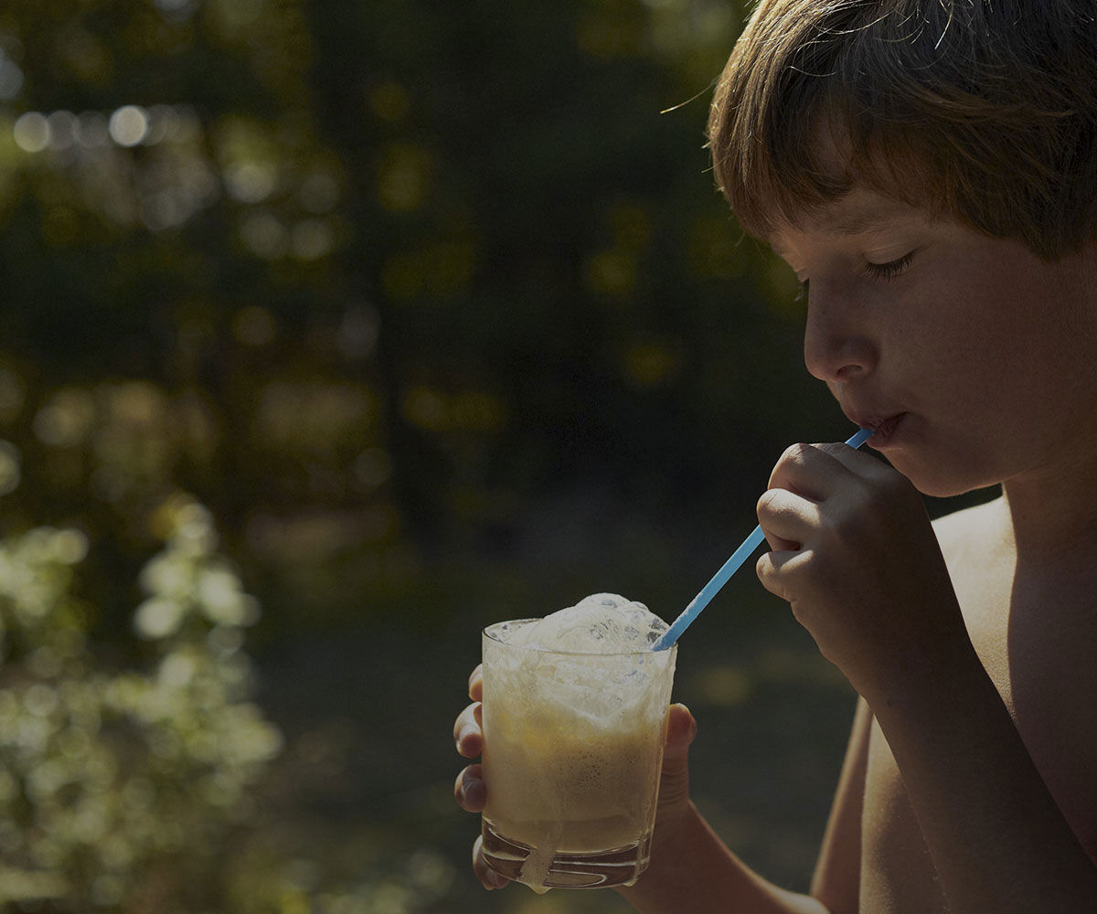 Boy drinking a milk drink outside
